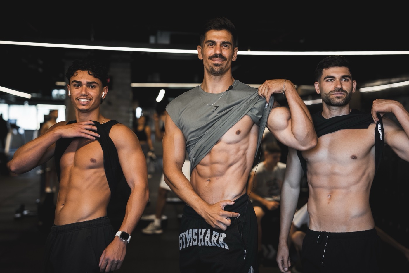 שלושה מתאמנים בליווי אופק זרמטי מציגים את התוצאות בחדר הכושר